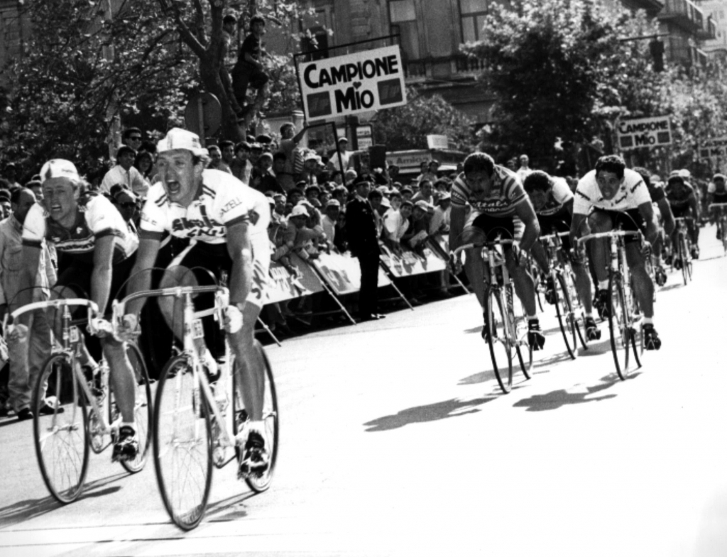 Jean-Paul van Poppel spurt vooraan in een kopgroep naar de ritzege in de Giro d'Italia, langs een bord met "Campione Mio"